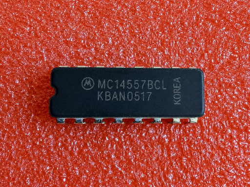 A Motorola MC14557BCL integrated circuit chip with the serial number KBAN0517, shown on a textured red background.